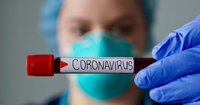 enfermeira segurando frasco com etiqueta escrito Coronavírus