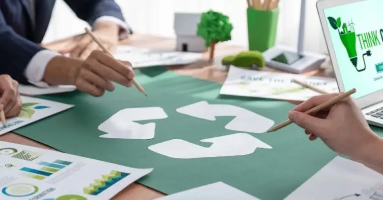 Profissionais reúnem-se em torno do símbolo de reciclagem para discutir o PGRS para empresas.